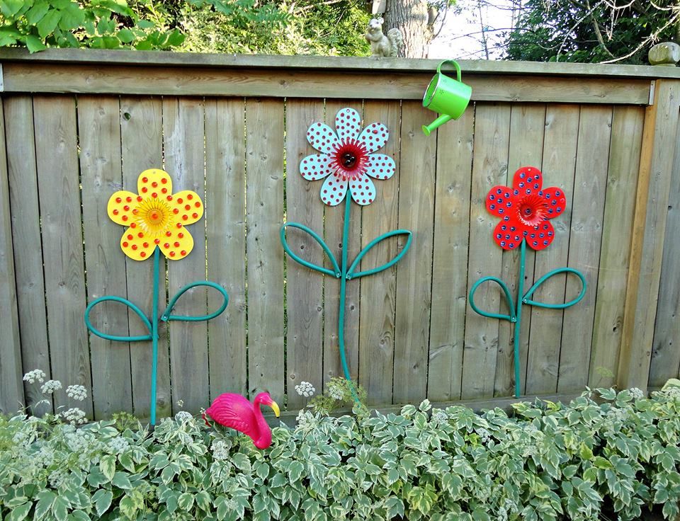 Dollar store flowers turned into garden art with hoses for leaves and
