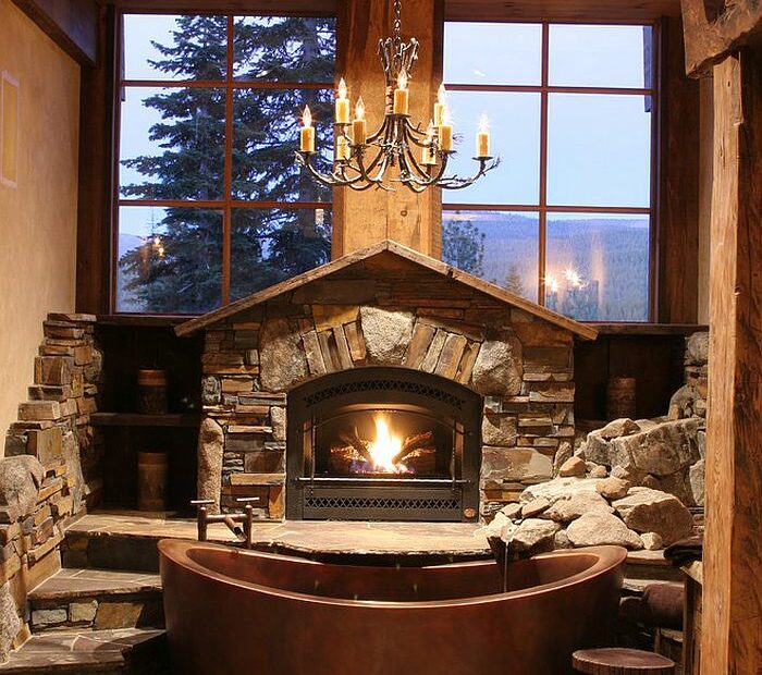Fabulous cabin style bathroom with copper bathtub fireplace and large windows
